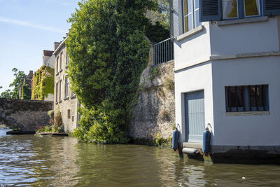 Building by river against sky