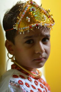 Close-up portrait of boy in krishna costume against wall