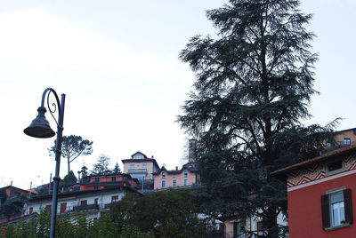 Low angle view of trees and buildings against sky