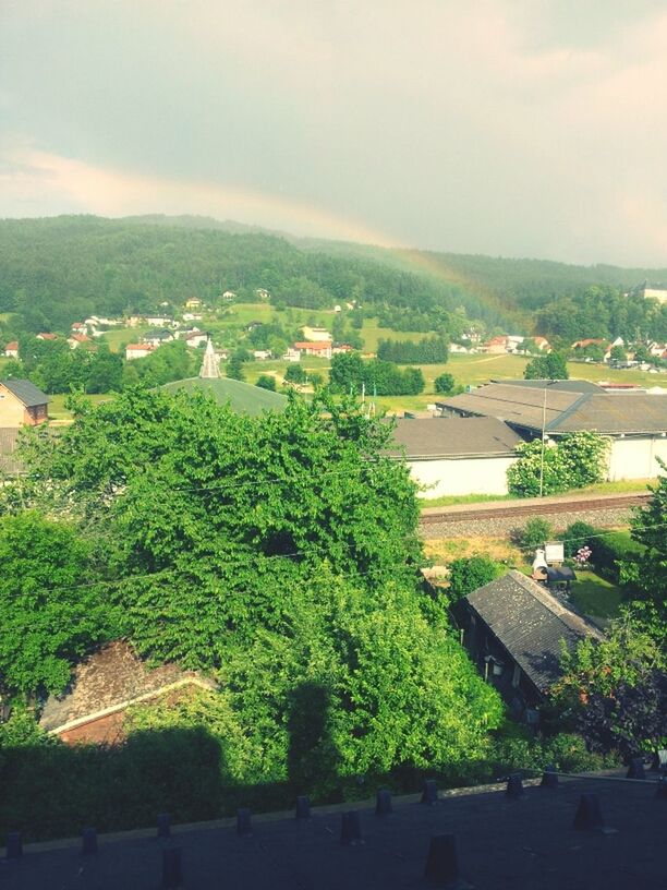 building exterior, sky, built structure, architecture, tree, cloud - sky, high angle view, mountain, landscape, house, roof, cloud, residential structure, growth, nature, green color, residential building, outdoors, day, town