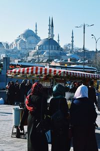 Rear view of people outside temple against clear sky