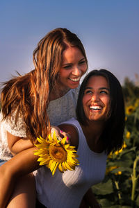 Smiling young women against blue sky