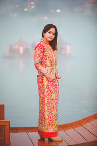 Asian woman wearing cheongsam traditional red dress on chinese new year travel.