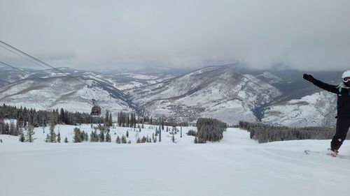 Snow covered land and mountains against sky