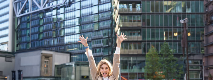 Rear view of woman with arms raised