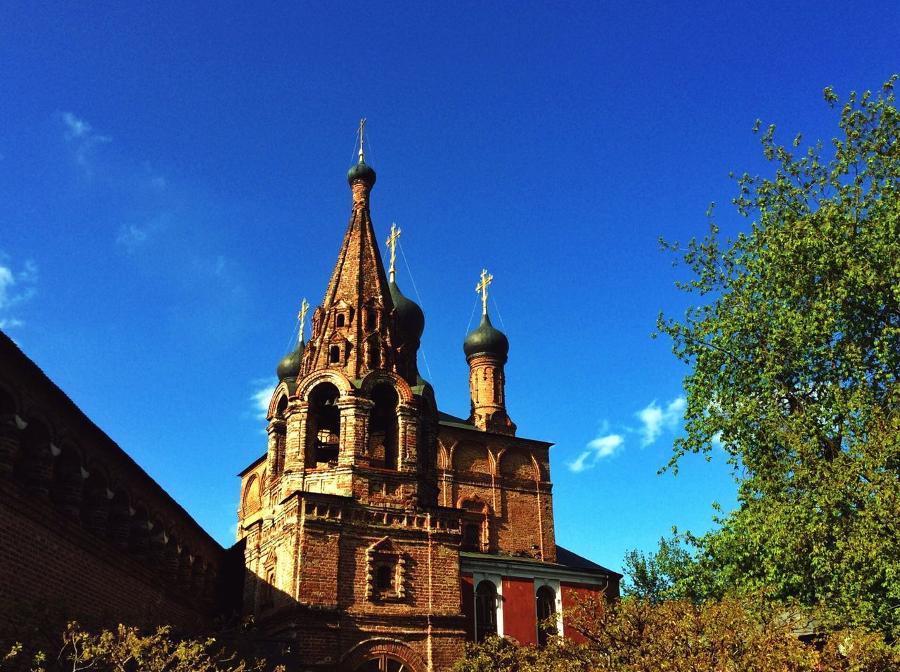 building exterior, architecture, place of worship, built structure, religion, church, spirituality, blue, low angle view, cathedral, tree, clear sky, sky, history, steeple, tower, famous place, travel destinations