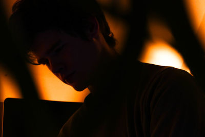 Close-up of sad young man in darkroom