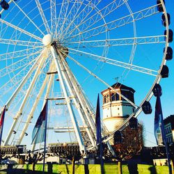 Low angle view of illuminated ferris wheel against blue sky