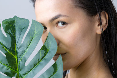 Close-up of young woman holding plant
