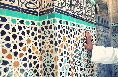 Man leaning on mosaic tiled wall