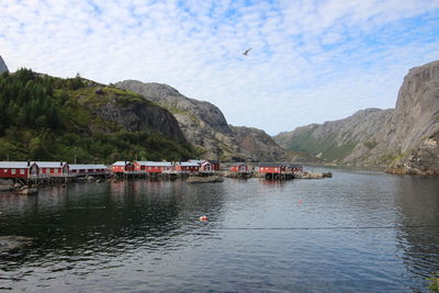 Scenic view of river by mountains against sky