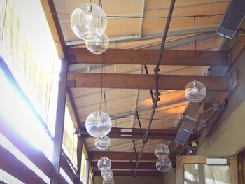 Low angle view of illuminated light bulbs hanging from ceiling