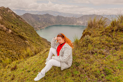 Woman standing on field by mountains against sky