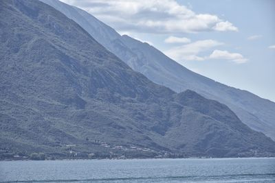 Scenic view of lake by mountains against sky