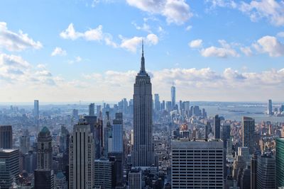 Modern buildings in city against cloudy sky