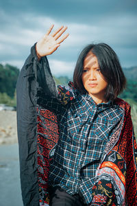 Portrait of woman standing against sky