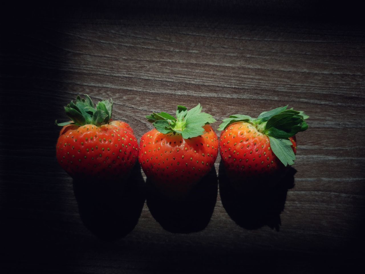 CLOSE-UP OF STRAWBERRIES ON TABLE AGAINST BACKGROUND