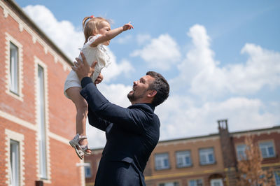 Low angle view of man and woman against building