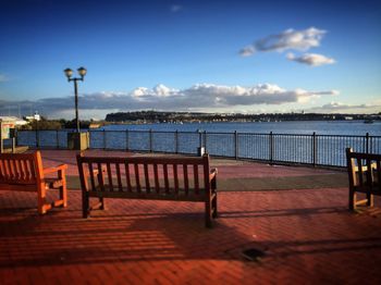 Pier on sea against cloudy sky