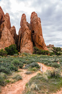 Rock formations on landscape against cloudy sky