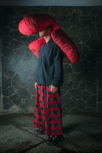 Rear view of woman standing against wall