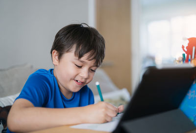 Portrait of boy using mobile phone at home