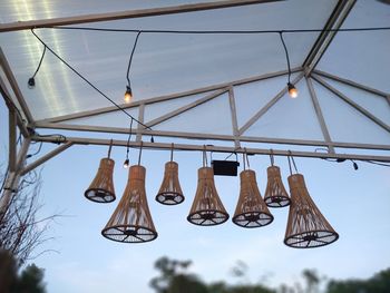 Low angle view of shoes hanging on rope against sky
