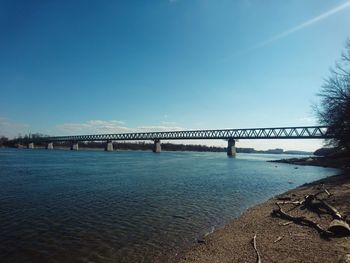 Bridge over water against blue sky