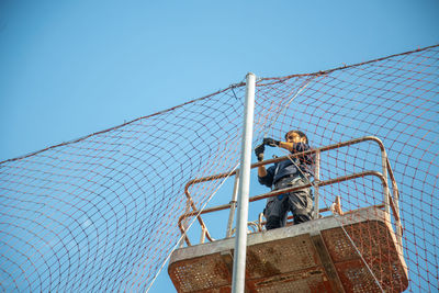 Low angle view of construction site against clear blue sky