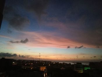 Illuminated buildings against sky during sunset