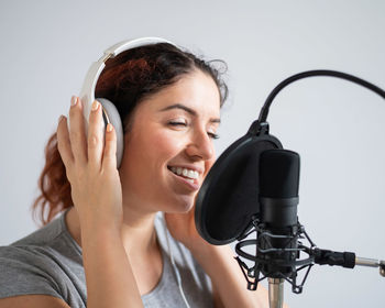 Woman singing against white background