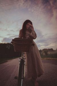 Woman standing on road against sky