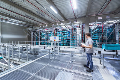 Man with documents in automatized high rack warehouse