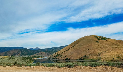 Scenic view of field and mountains against sky