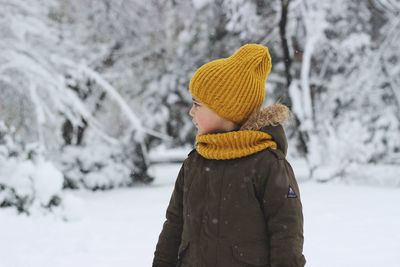 Boy standing on snowy field