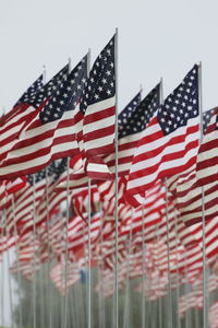 Close-up of american flags against sky