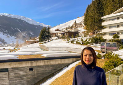 Portrait of young woman standing against mountain