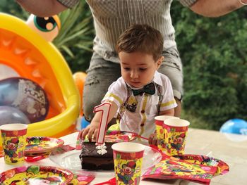 Baby boy touching cake