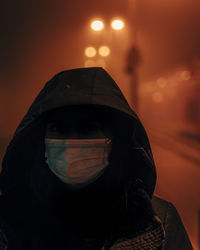 Portrait of man against illuminated orange sky