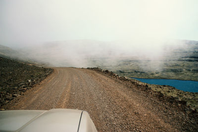 Road by landscape against sky