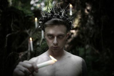 Portrait of young man holding cigarette outdoors