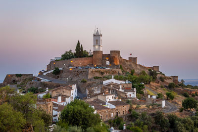 View of old buildings in town against sky