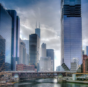 Buildings in city against cloudy sky