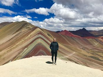 Full length of woman standing on mountain against sky