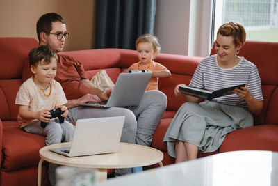 Big happy family watching movies playing games on laptop. mother father kids spending time with