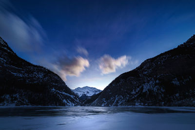 Scenic view of lake by mountains against sky