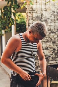 Man removing wallet from pouch while standing outdoors