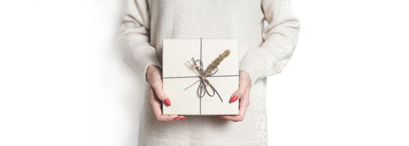 Close-up of woman holding hands over white background