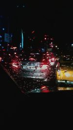 Illuminated cars on road in city at night