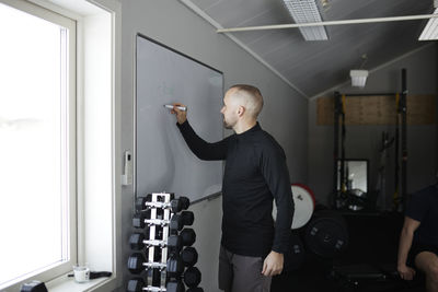 Man writing on whiteboard in gym